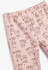 Helle rosa Leggings mit einem wiederholten braunen Fuchs-Muster, ausgestattet mit einem elastischen Bund und einer glatten, weichen Textur.