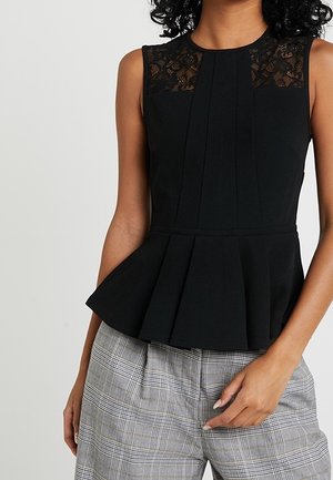 Ärmelloses schwarzes Peplum-Oberteil mit Spitzeneinsatz am Ausschnitt, kombiniert mit hoch taillierter grau karierter Hose.