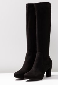 Botas negras hasta la rodilla, hechas de suave ante, con puntera afilada, tacón grueso y detalles laterales con un acento de logotipo.