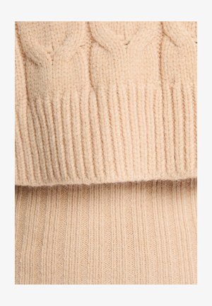 Maglione lavorato a maglia in morbida lana beige, con un motivo a treccia testurizzato nella parte superiore e orlo a coste. Texture liscia con un aspetto caldo.