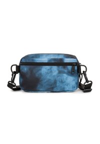 Klein rechthoekig crossbodytasje met zwart en blauw tie-dye patroon, vooraan een ritszak en een verstelbare zwarte schouderband met clips.