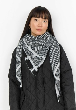 Mustvalge sall geomeetriliste mustrite ja ruudulise disainiga. Kandmiseks on see seotud kaela ümber musta tikandiga jope peal.