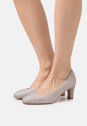 Tacones de brillo color oro rosa con punta redondeada, tacón bajo tipo bloque y superficie texturizada, que presentan un acabado suave y brillante.