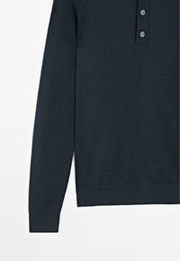 Maglione lavorato a maglia blu navy con collo a polo, presenta tre bottoni, maniche lunghe e bordi a coste su orlo e polsini. Tessuto liscio.