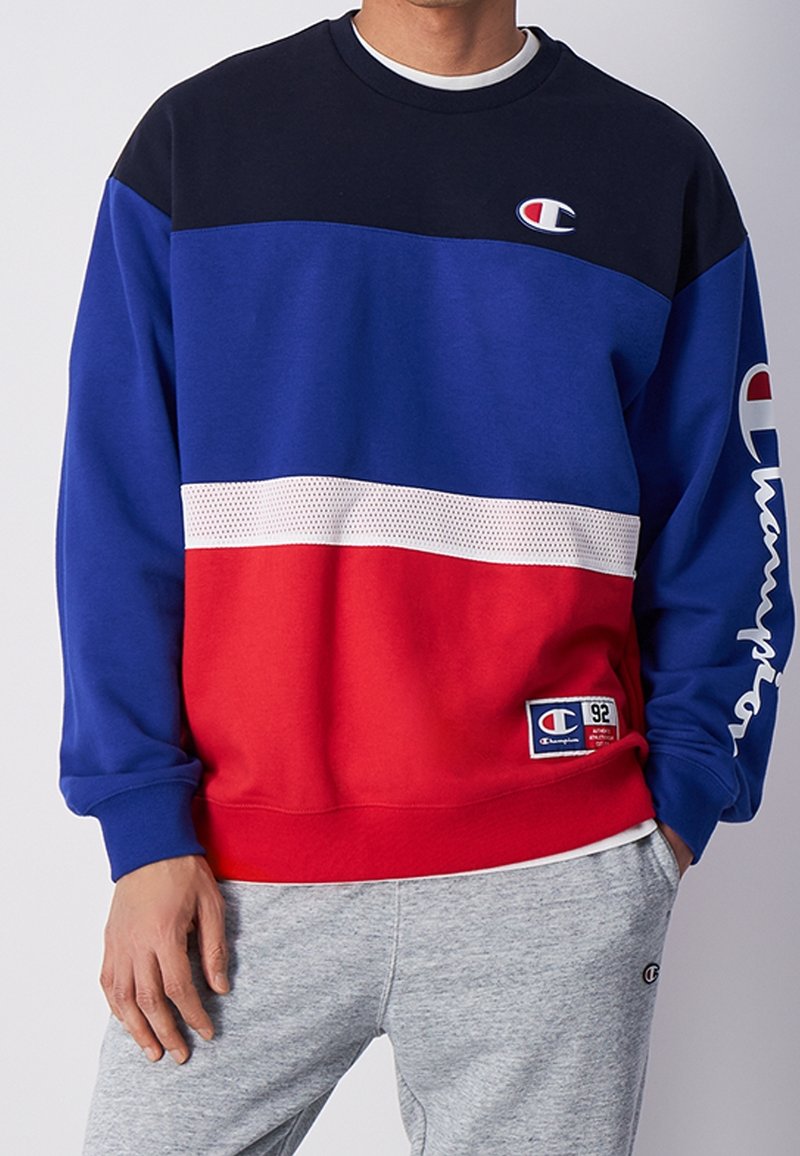 Farbblockierter Sweatshirt in Marineblau, Königsblau und Rot. Verfügt über einen Mesh-Streifen und ein gesticktes Logo. Rippbündchen und Saum.