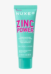 NUXE Zinc Power, 40 ml, i en turkos tub med ett flip-top lock. Har fet rosa text för produktnamnet, med ytterligare detaljer i vitt.