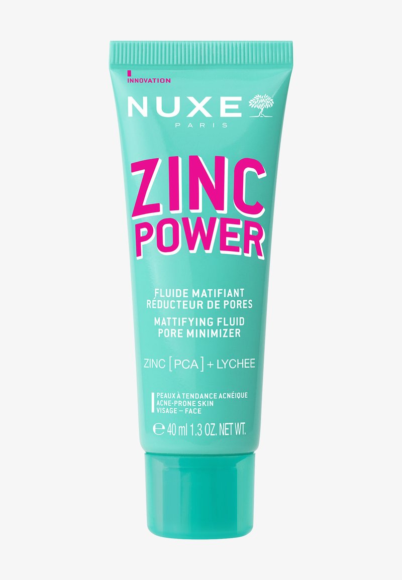 NUXE Zinc Power, 40 ml, en un tubo turquesa con tapa de flip-top. Presenta un texto rosa intenso para el nombre del producto, con detalles adicionales en blanco.