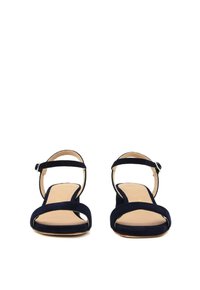 I sandali in suede blu navy presentano una punta aperta e una cinghia alla caviglia con fibbia. Il design include una parte superiore minimalista e una suola piatta.