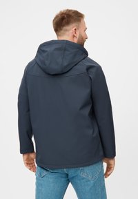 Giacca con cappuccio blu navy dal tessuto liscio, con design leggermente aderente e una semplice cucitura sul retro, abbinata a jeans in denim azzurro chiaro.