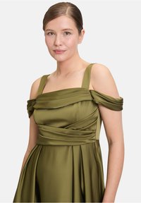 Olivgrünes Satin-Kleid mit schulterfreien Ärmeln, quadratischem Ausschnitt und gefalteten Details am Oberteil und Rock. Glatte Textur.