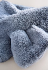 Soft faux fur scarf in light blue. Features a dense, plush texture with varying shades and lengths of fur, creating a layered appearance.