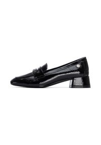 Mocasines de charol negro con un tacón bajo, que cuentan con una correa decorativa y un pequeño logo en el lado.