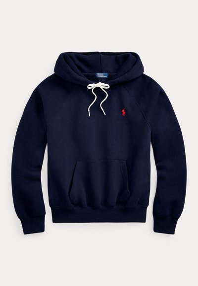 Φόρμα με κουκούλα σε ναυτικό μπλε χρώμα, λευκά κορδόνια, μπροστινή τσέπη τύπου καγκουρό και μικρό κόκκινο κεντημένο λογότυπο αλόγου στο αριστερό μέρος του στήθους.