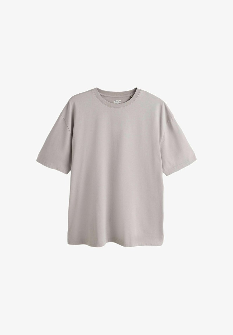 Maglietta grigia chiaro oversize a maniche corte con scollo rotondo, mostrata distesa su uno sfondo bianco.