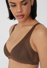 Bralette en forma de triángulo marrón, hecho de una tela suave con acentos transparentes. Las tirantes ajustables y un sutil diseño en forma de v realzan su forma.