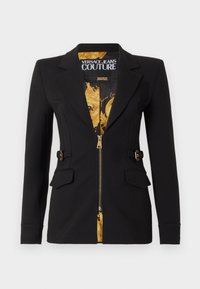 Μαύρο εφαρμοστό σακάκι με χρυσό σχέδιο στο εσωτερικό φόδρα, χρυστό φερμουάρ στο μπροστινό μέρος, τσέπες με καπάκι και μικρές λεπτομέρειες με αγκράφα στα πλάγια.