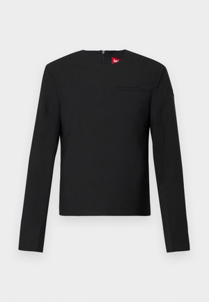 Sort langærmet top med rund hals og minimalistisk design. Har en lille brystlomme og en lynlås lukning på ryggen. Glat tekstur.