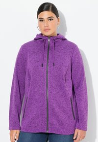 Lila fleece zip-up hoodie med en strukturerad yta, justerbar dragkedja på huvan och svarta dragkedjedetaljer. Sidofickor för praktisk användning.