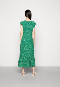 Grünes Maxikleid mit kurzen rüschenbesetzten Ärmeln, gestuftem Saum und tailliertem Oberteil. Verfügt über ein farbenfrohes Blumenmuster auf einem lebhaften Hintergrund.