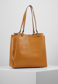 Torebka tote w kolorze tan z ekoskóry o teksturowanej powierzchni, z dwoma ramiączkami oraz złotymi akcentami, oferująca przestronną wnętrze.