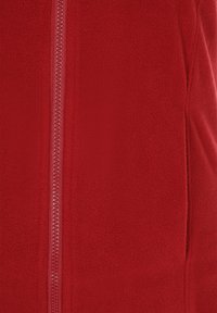 Czerwona polarowa kurtka z zamkiem błyskawicznym na całej długości z przodu, wykonana z miękkiego materiału o gładkiej fakturze i jednolitym wykończeniu.