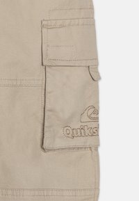 Beige cargo shorts med frontlomme og broderte logo detaljer. Laget av lettvektig stoff, med jevn tekstur og et enkelt design.
