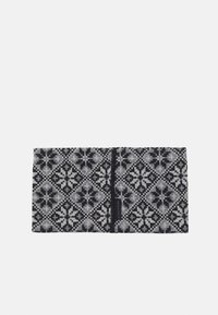 Stickad huvudband i svart och grått, med ett geometriskt mönster av diamanter och blommiga accenter. Mjuk, strukturerad tyg med en söm.