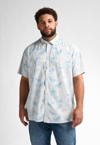 Camicia a maniche corte con bottoni, sfondo chiaro e modelli floreali e fogliari blu. Realizzata in un tessuto leggero.