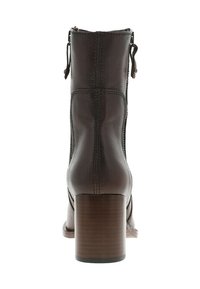 Bottine en cuir marron avec un talon carré, présentant une texture lisse, des coutures contrastées et des accents en boucle double sur les côtés.