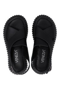Zwarte sandalen met kruisbanden, gemaakt van glad synthetisch materiaal, met een dikke, gestructureerde rubberen zool en een zijgesp-detail.
