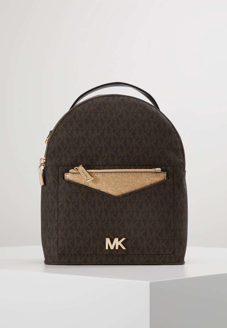 Sac à dos Michael Kors marron foncé avec poche avant zippée dorée et logo MK, présenté sur une plateforme blanche sur fond uni.