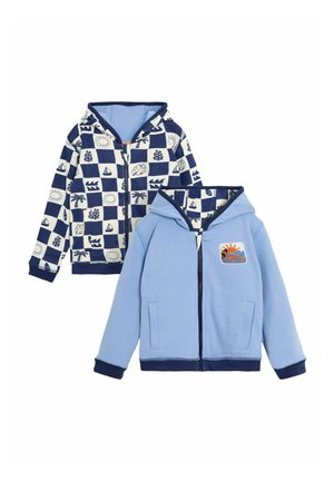 Katoenen zip-up hoodies; de ene heeft een marineblauw en wit nautisch patroon, de andere is effen lichtblauw met een zon grafiek en marineblauwe accenten.