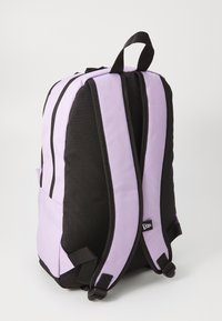 Backpack with a lavender and black color scheme, made of fabric. Features padded straps, a side pocket, and contrasting vertical stripes.