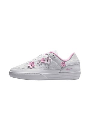 Białe niskie sneakersy z różowymi aplikacjami kwiatów i różową wyściółką, z małym różowym logo Nike po boku.