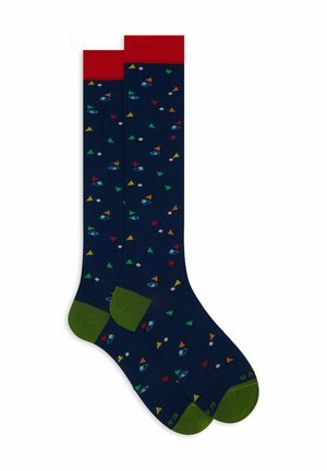 Marineblaue Socken mit einem roten Bündchen und grüner Ferse, die ein Muster aus bunten Dreiecken, Augen und Planeten in verschiedenen Farben zeigen. Aus einem Baumwollgemisch.
