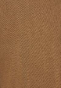 Close-up van een bruine gebreide stof met fijne, gelijkmatige steken en een zachte textuur.