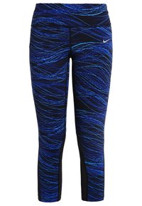 Leggings Nike con un motivo a onde blu su uno sfondo nero, realizzati in tessuto elasticizzato, con una vita alta e una vestibilità affusolata.