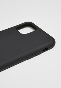 Husa neagră pentru smartphone cu un finisaj mat, având decupaje pentru cameră și porturi, precum și butoane texturate pe laterale.