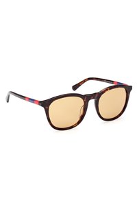 Gafas de sol de carey con lentes amarillos. La montura de acetato presenta acentos rojos y azules en las patillas. Forma cuadrada con textura suave.