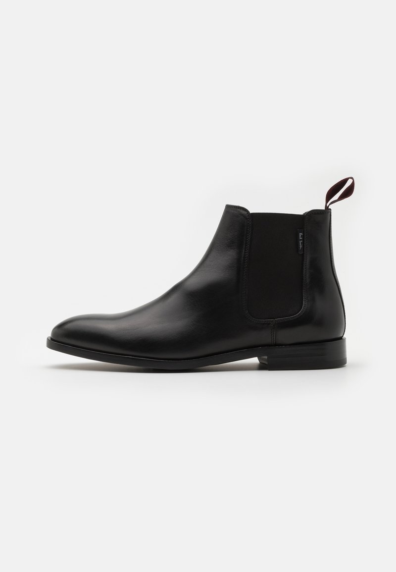 Botte Chelsea en cuir noir avec panneau latéral élastique et languette de maintien, talon bas et bout arrondi lisse, vue de côté extérieur.
