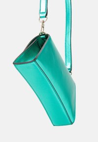 Teal, glossy synthetic handbag with a geometric shape, featuring a black trim and a detachable shiny strap.