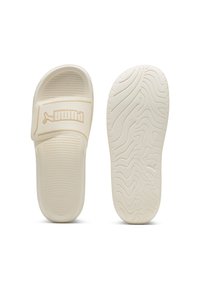 Infradito Puma con una fascia bianca testurizzata e suola, caratterizzati da un logo discreto. La suola presenta un motivo ondulato per garantire aderenza.