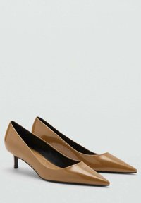 Beige nahkakengät, joissa on terävä kärki ja kapea 4 cm:n kitten-korko, sekä kiiltävä pinta. Sisäosa on musta, luoden kontrastia.