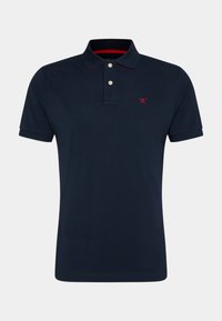 Granatowy polo z krótkim rękawem z dwoma białymi guzikami, czerwoną lamówką wewnątrz kołnierzyka oraz małym czerwonym logo dwóch skrzyżowanych kijów golfowych na lewej piersi.