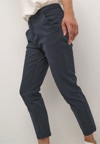 Navyblå chinos med slim fit, med knappstängning och framfickor. Tillverkade av lättviktig tyg med en slät textur.