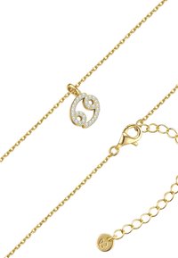 Zelta krāsas kaklarota ar pusmēness formas piekariņu, kas rotāts ar caurspīdīgiem, mirdzošiem akmeņiem. Ķēde aprīkota ar omālu stiprinājumu un ir regulējama garumā.