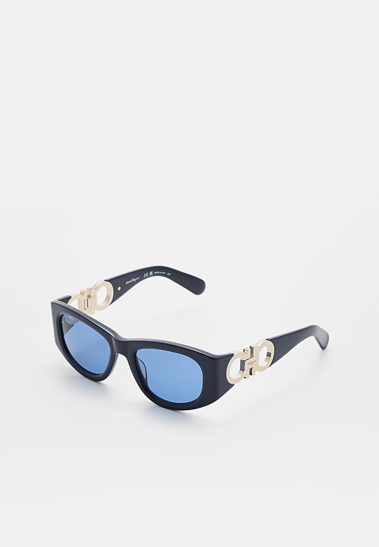Schwarze Sonnenbrille mit goldenen Akzenten, kantigem Design und blauen getönten Gläsern. Verfügt über ein auffälliges Logo an den Bügeln. Hergestellt aus strapazierfähigem Kunststoff.