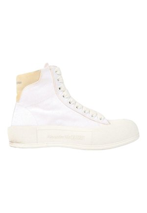 High-top white sneaker with lace-up front, textured sole, beige heel patch, and "Alexander McQUEEN" branding on the side.