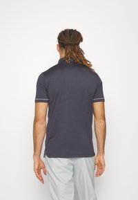 Tmavě modrá polokošile s krátkým rukávem, která má jemnou strukturu, límec a kontrastní bílé pruhy na rukávech.