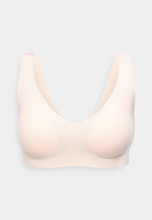 Seamless, light beige wireless bra with wide straps and molded cups, designed for comfort and smooth fit.